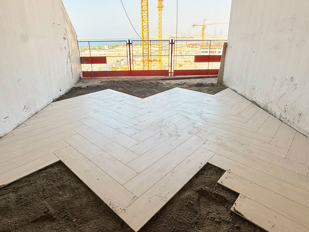 Beach Walk Iii By Imtiaz An unfinished room with herringbone-patterned flooring and a view of construction outside.